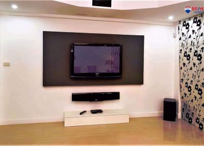 Modern and spacious living room with mounted television and decorative wallpaper