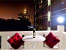 Cozy balcony at night with a table set for two and urban skyline in the background