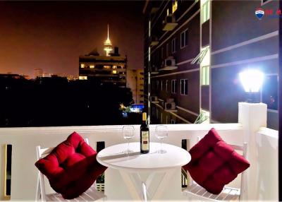 Cozy balcony at night with a table set for two and urban skyline in the background