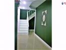 White staircase in a modern home with a dark green accent wall