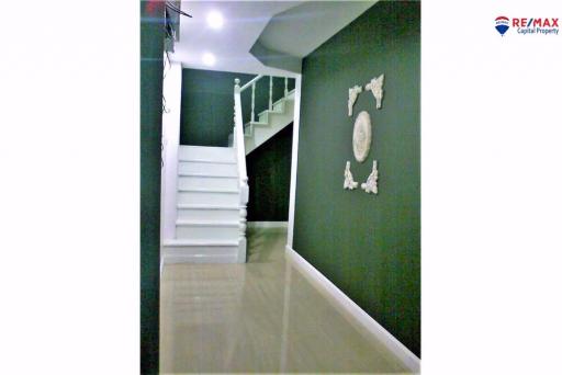 White staircase in a modern home with a dark green accent wall