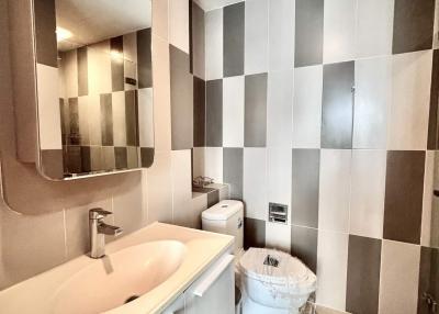 Modern bathroom with checkered wall tiles and sleek fixtures