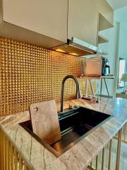 Modern kitchen with gold backsplash and marble countertops