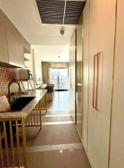 Modern kitchen with open layout leading to a well-lit living area