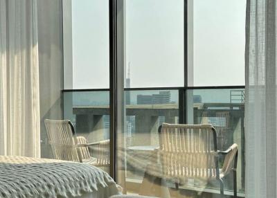 Modern bedroom with floor-to-ceiling windows and access to balcony