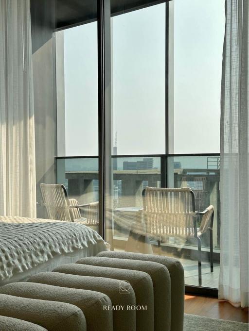 Modern bedroom with floor-to-ceiling windows and access to balcony