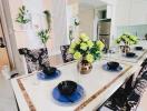 Modern kitchen with dining area, decorated with flowers and place settings