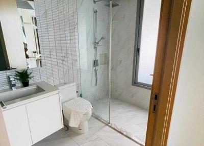 Modern bathroom interior with glass shower and marble tiles