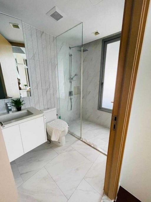 Modern bathroom interior with glass shower and marble tiles