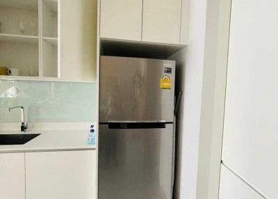 Modern kitchen with stainless steel refrigerator and white cabinetry