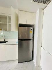 Modern kitchen with stainless steel refrigerator and white cabinetry