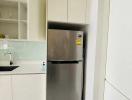 Modern kitchen with stainless steel refrigerator and white cabinetry