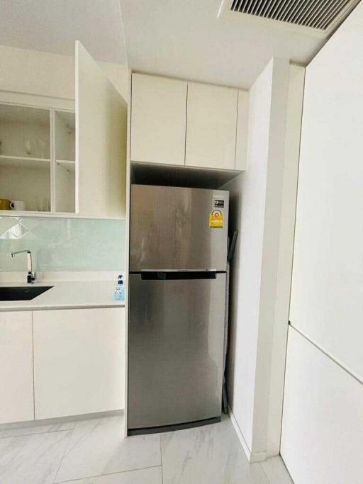 Modern kitchen with stainless steel refrigerator and white cabinetry