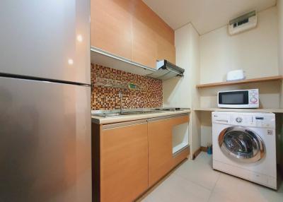 Compact modern kitchen with stainless steel appliances and mosaic backsplash