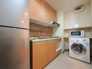 Compact modern kitchen with stainless steel appliances and mosaic backsplash