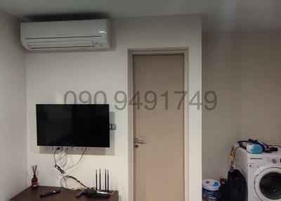Compact living room with mounted television and air conditioning unit