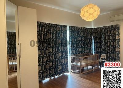 Spacious bedroom with crib and printed curtains