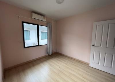 Empty bedroom with pink walls and wooden flooring