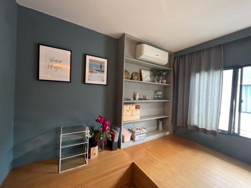 Cozy bedroom with grey walls, natural light, and shelving units