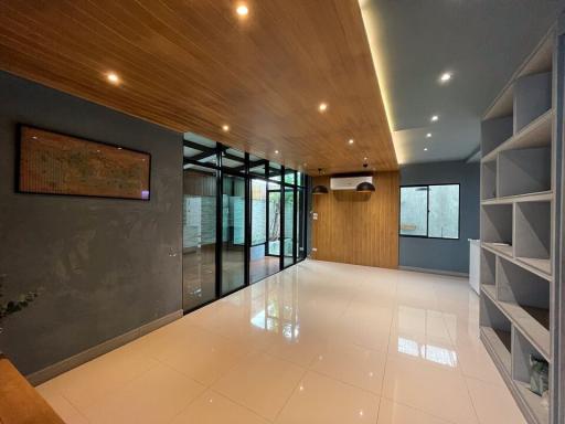 Modern interior with polished floor, glass doors, and wooden ceiling