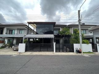 Modern two-story house with large windows and a protective fence