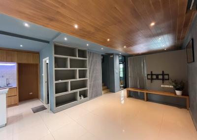 Spacious and modern living room with wood ceiling and tiled floor