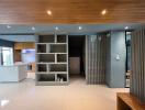 Modern open-concept living area with kitchen and shelving unit