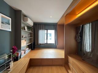 Modern bedroom with hardwood flooring, built-in storage, and abundant natural light