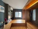 Modern bedroom with hardwood flooring, built-in storage, and abundant natural light
