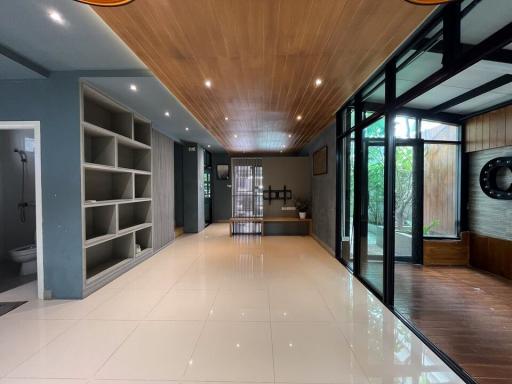 Spacious and modern interior with wooden accents, large windows, and glossy floor