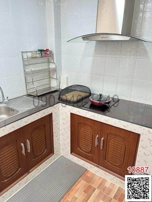 Compact kitchen with stainless steel sink and modern cooktop