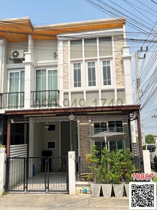 Modern two-story house with a small balcony and a gated entrance