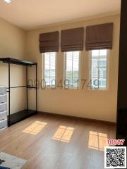 Empty bedroom with natural light and hardwood floors