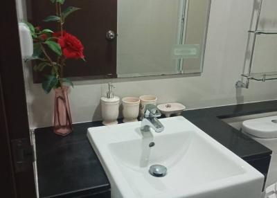 Modern bathroom interior with square sink, mirror, and decorative flowers