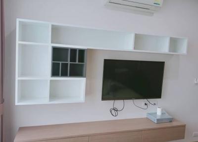 Modern living room interior with mounted television and shelving units