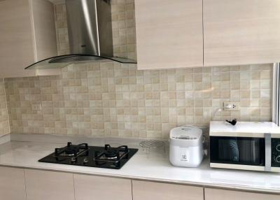 Modern kitchen with stainless steel appliances and beige tile backsplash