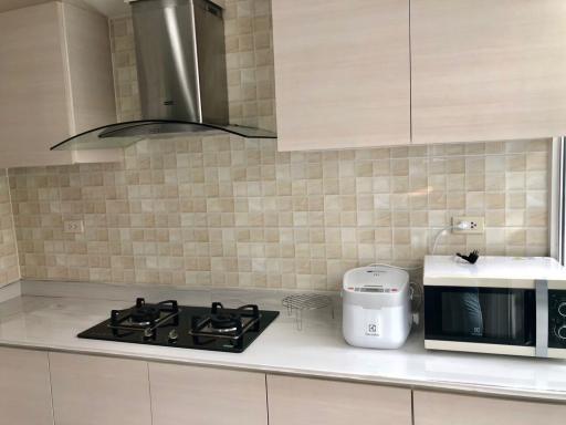 Modern kitchen with stainless steel appliances and beige tile backsplash