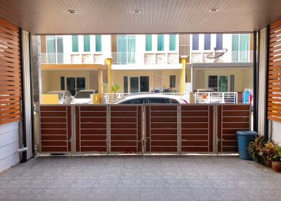 View of a residential building entrance with parked cars and visible balconies