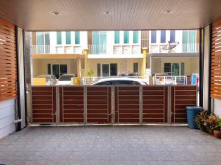 View of a residential building entrance with parked cars and visible balconies