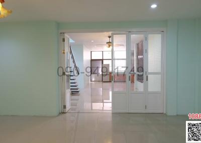 Bright and spacious home entryway with staircase and living space in the background