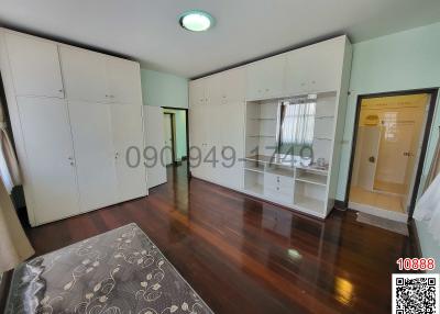 Spacious modern bedroom with large wardrobes and hardwood flooring