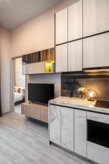 Modern studio apartment interior with integrated kitchen and entertainment unit