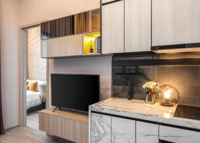 Modern studio apartment interior with integrated kitchen and entertainment unit