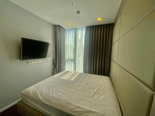 Modern bedroom with large bed and mounted television