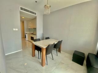 Modern dining area with open kitchen in the background