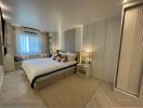 Modern bedroom with neutral tones and ample lighting