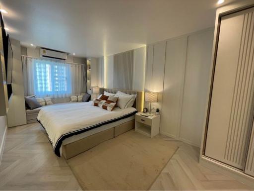 Modern bedroom with neutral tones and ample lighting