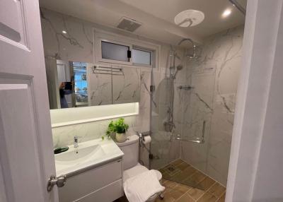 Modern marble-lined bathroom with walk-in shower and sleek fixtures