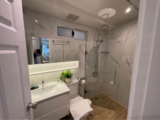 Modern marble-lined bathroom with walk-in shower and sleek fixtures