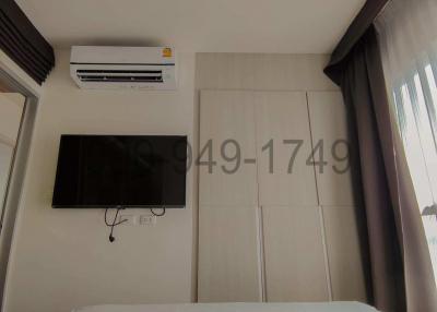 Modern bedroom with mounted television and air conditioner